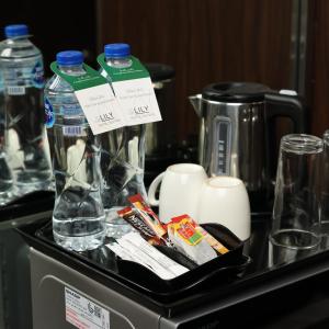 eine Theke mit einem Tablett mit Wasserflaschen darauf in der Unterkunft Lily Hotel Suite Hofuf in Al Hofuf