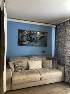 un sofá en una sala de estar con una pared azul en Cervinia – Matterhorn Apartments, en Breuil-Cervinia