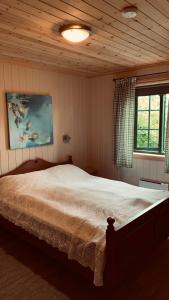 1 dormitorio con 1 cama y una pintura en la pared en Panorama Logde Stryn, with Jacuzzi, Sauna and Spectacular Views! en Stryn