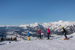 4 personas en esquís en la cima de una montaña en Ferienwohnung Gipfelblick, en Weerberg