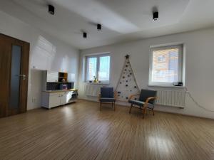 a living room with two chairs and a christmas tree at Tatry Mountain Paradise in Poprad