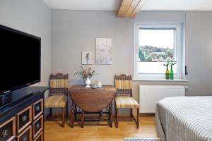 een slaapkamer met een eettafel met stoelen en een televisie bij Vogelsberger Cosy Home-ganzes Haus 