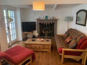 a living room with a couch and a tv at Character Cottage in Gunnislake in Gunnislake