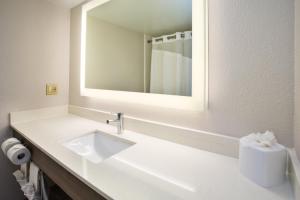 Baño blanco con lavabo y espejo en Holiday Inn Express Nashville Airport, an IHG Hotel en Nashville