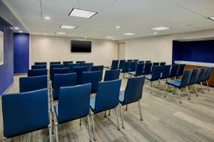 a conference room with blue chairs and a screen at Holiday Inn Express Nashville Airport by IHG in Nashville +37 photos