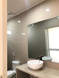 W łazience znajduje się umywalka, toaleta i lustro. w obiekcie L'JAVAS VILLAS w mieście Kalibendo