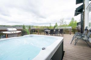 耶姆塞的住宿－Villa Peso2 - 8 henkilölle, HimosYkkösen alue, 70m²+40m²，甲板上的热水浴池配有桌椅