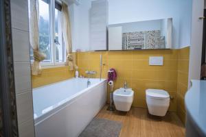 uma casa de banho com uma banheira, um WC e um lavatório. em Casa Gioia em Nebbiuno