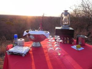 a red table with wine glasses and a bowl on it at Selwane Nature Reserve in Gravelotte