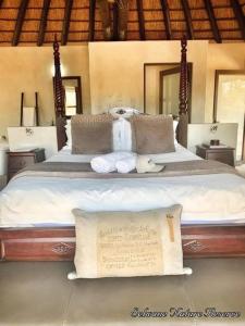 a bedroom with a large bed with towels on it at Selwane Nature Reserve in Gravelotte