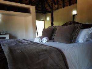 a bedroom with a large bed with white sheets and pillows at Selwane Nature Reserve in Gravelotte