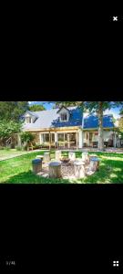 a large house with a yard with benches in front of it at 1 Croft Cottage, in Knysna
