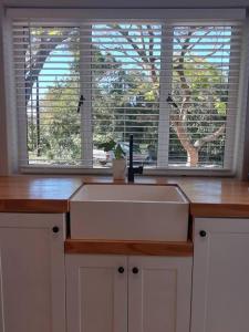 a kitchen counter with a sink and a window at 1 Croft Cottage, in Knysna
