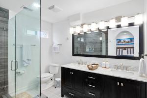 uma casa de banho com um chuveiro, um lavatório e um WC. em Coastal-Inspired Home near Beach & Village em San Diego