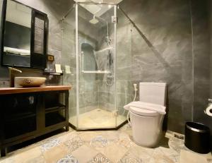 a bathroom with a shower and a toilet and a sink at CHECK inn Phnom Penh BKK1 in Phnom Penh +17 photos