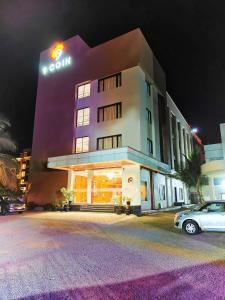 a building with a car parked in front of it at Hotel 9 Coin in Shirdi