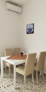 a white dining room table with chairs and a white wall at La Casa di Dany in Rome
