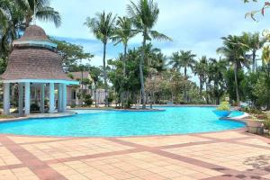 a large swimming pool with a gazebo and palm trees at Hidden Gem: Cebu's Best Escape in Talisay
