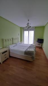 Un dormitorio con una cama grande y una ventana en Chalet Aia -Naturaleza y seguridad, entorno rural a 29 km de San Sebastian, en Aia