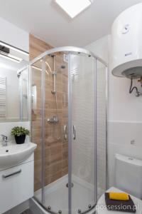 a bathroom with a shower and a sink at Mikrokawalerki w sercu Gdańska in Gdańsk