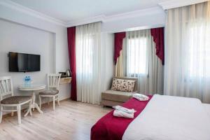 une chambre d'hôtel avec un lit, une table et des chaises dans l'établissement NACRE RESIDENCE, à Istanbul