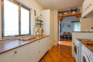 uma cozinha com armários brancos e uma janela em Villa nel bosco em Gromlongo