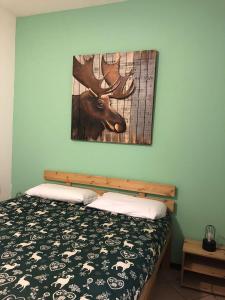 ein Schlafzimmer mit einem Bett mit einem Bild eines Elchs an der Wand in der Unterkunft Cervinia – Matterhorn Apartments in Breuil-Cervinia