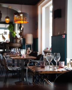 ジュルヴィル・レ・パンにあるHôtel des Pinsのワイングラス付きのテーブルと椅子のあるレストラン