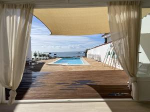 uitzicht op een zwembad vanaf de veranda van een huis bij La Sirena del Viento in Los Caños de Meca