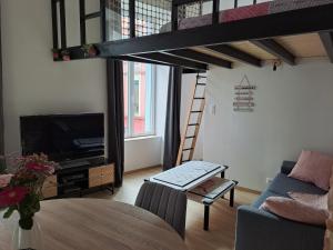 a living room with a loft bed and a table at Le Q'vier in Montbéliard