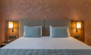 a bedroom with a large bed with two pillows at Riu Plaza The Gresham Dublin in Dublin