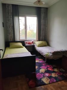 two beds in a room with a window and a rug at Beylikdüzü merkez site içi daire in Beylikduzu