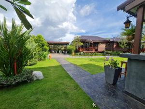 Ban Na Tai的住宿－Baan Ati Resort & Spa，一座带房子和草地庭院的花园