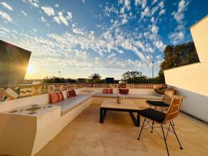 a rooftop patio with a couch and a table at Casa de la Risa - Sotogrande house with rooftop pool in San Enrique de Guadiaro