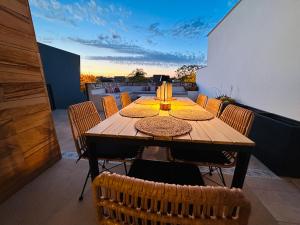 a wooden table on a balcony with chairs around it at Casa de la Risa - Sotogrande house with rooftop pool in San Enrique de Guadiaro