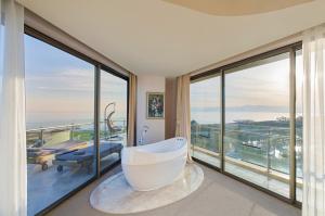 a bathroom with a bath tub and a large window at Maxx Royal Belek Golf Resort in Belek
