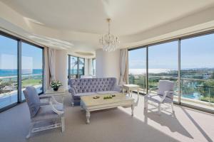 a living room with a couch and chairs and windows at Maxx Royal Belek Golf Resort in Belek