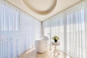 una vasca da bagno in una stanza con ampie finestre di Maxx Royal Belek Golf Resort a Belek