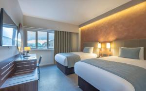 a hotel room with two beds and a window at Riu Plaza The Gresham Dublin in Dublin