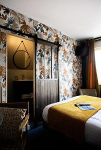 Pokój hotelowy z łóżkiem i lustrem w obiekcie Hôtel des Pins w mieście Jullouville-les-Pins