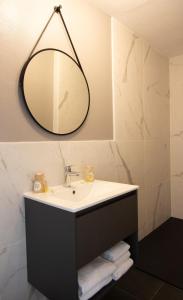 a bathroom with a sink and a mirror at Hôtel des Pins in Jullouville-les-Pins
