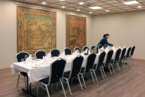 a woman in a room with a table and chairs at Henriks Hotell in Skien