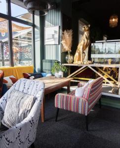 a living room with two chairs and a wooden table at Hôtel des Pins in Jullouville-les-Pins