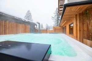 a swimming pool with snow on top of it at AlpinSpa zur Post in Bad Gastein
