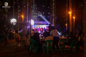 a group of people sitting at tables in front of a stage at night at Kabalega Resort - Masindi in Masindi +108 photos