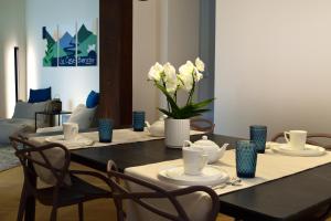 una mesa de comedor con flores blancas y jarrones azules en B&B Case Bianche, en Maranello