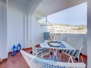 a white dining room with a table and chairs at HH Pueblo Butterfly in Benalmádena