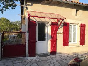 una casa con cortinas rojas y una puerta blanca en L 'ALBIZIA, en Chauvigny