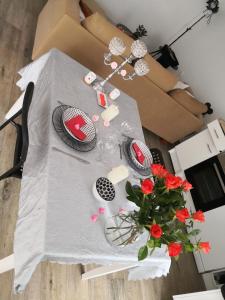 una mesa con un jarrón de flores rojas. en L 'ALBIZIA, en Chauvigny