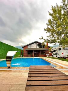 a house with a swimming pool next to a rv at sapancafamilyresort Isıtmalı jakuzili havuzu ile Ahşap aile villası in Kartepe
